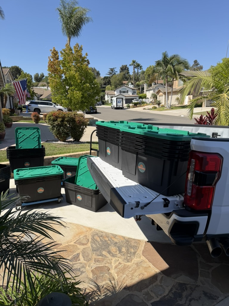 Totes and a dolly unloaded on a driveway for a Ventura County move