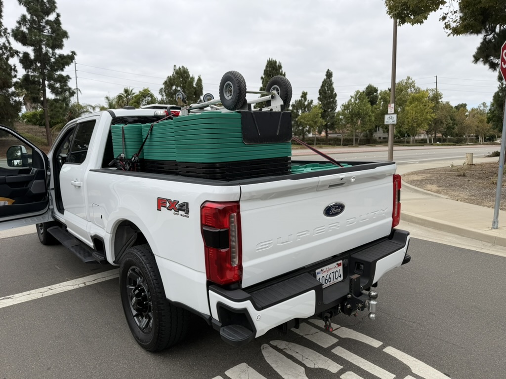 805 Totes truck bed loaded with green-lid moving totes and a dolly